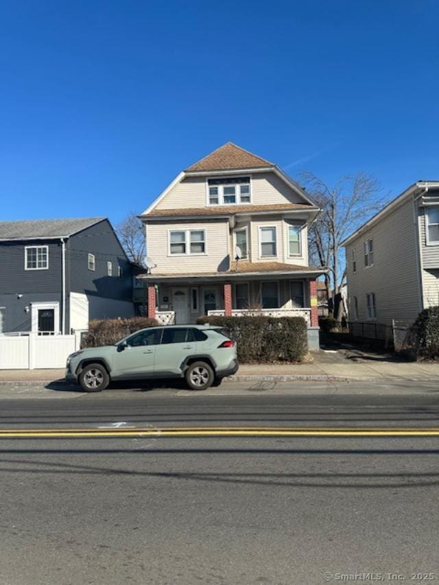 american foursquare style home featuring fence