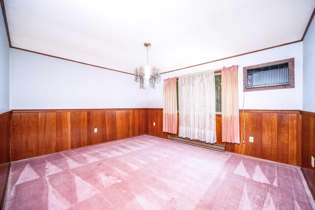 27 Mountain View Dr, East Hartford, CT 06117 - carpeted empty room with wooden walls, baseboard heating, a wainscoted wall, a wall mounted air conditioner, and a chandelier