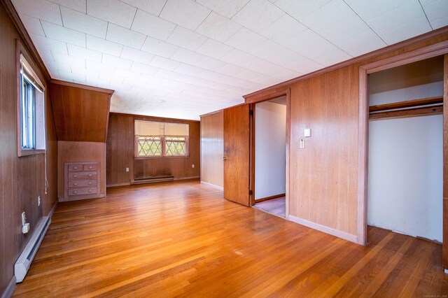 27 Mountain View Dr, East Hartford, CT 06117 - unfurnished bedroom featuring a baseboard heating unit, light wood finished floors, a closet, a baseboard radiator, and wooden walls