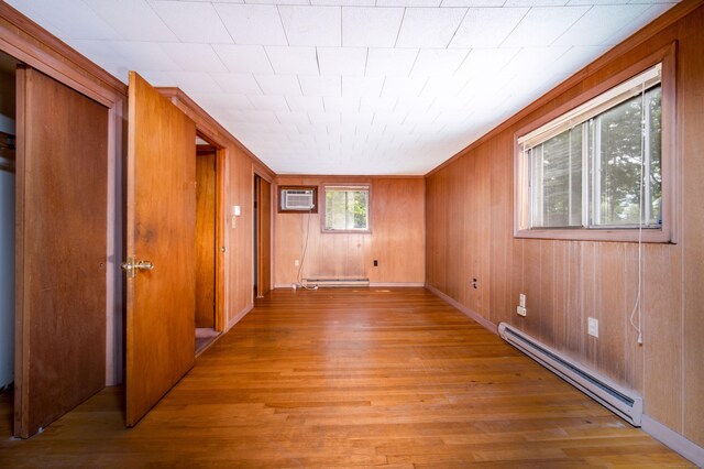 27 Mountain View Dr, East Hartford, CT 06117 - unfurnished room with a baseboard radiator, light wood finished floors, a baseboard heating unit, wood walls, and a wall unit AC
