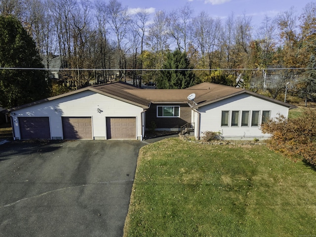 ranch-style home featuring brick siding, driveway, an attached garage, and a front yard