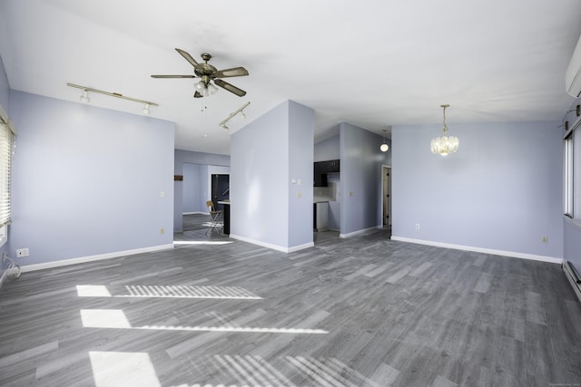 unfurnished living room featuring ceiling fan with notable chandelier, lofted ceiling, baseboards, and wood finished floors