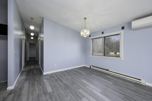 empty room with an AC wall unit, wood finished floors, baseboards, baseboard heating, and a chandelier