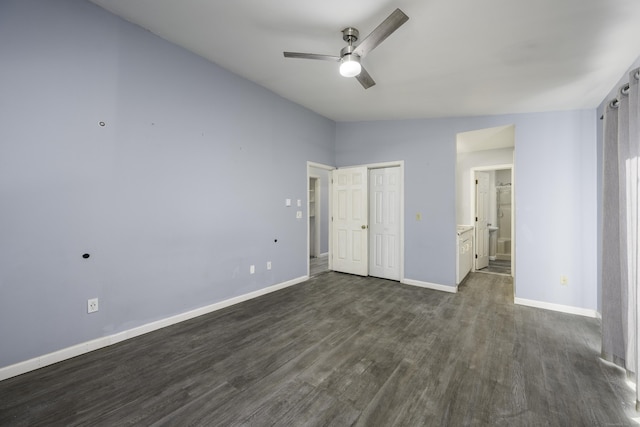 unfurnished bedroom with lofted ceiling, a ceiling fan, ensuite bath, baseboards, and dark wood-style flooring