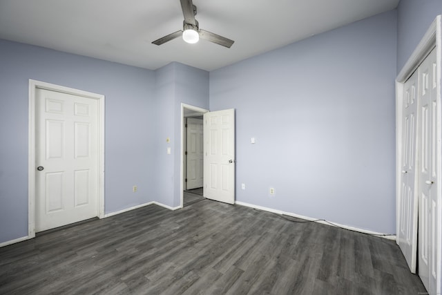 unfurnished bedroom with a closet, a ceiling fan, dark wood-type flooring, and baseboards