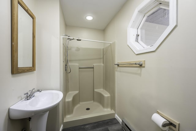 full bath with a sink, baseboards, a stall shower, and wood finished floors