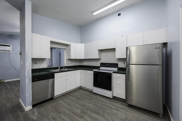 kitchen with dark countertops, a high ceiling, white cabinets, stainless steel appliances, and a sink