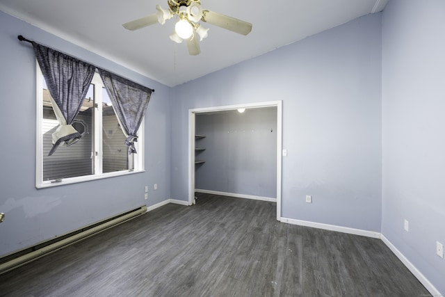 spare room with a baseboard heating unit, baseboards, vaulted ceiling, wood finished floors, and a ceiling fan