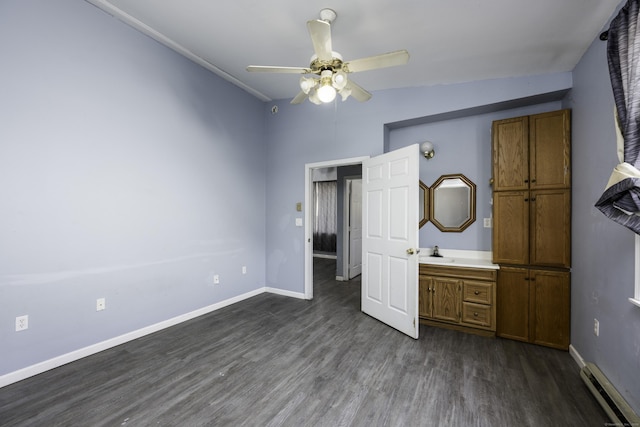 unfurnished bedroom with baseboards, a baseboard radiator, lofted ceiling, dark wood-style flooring, and a sink