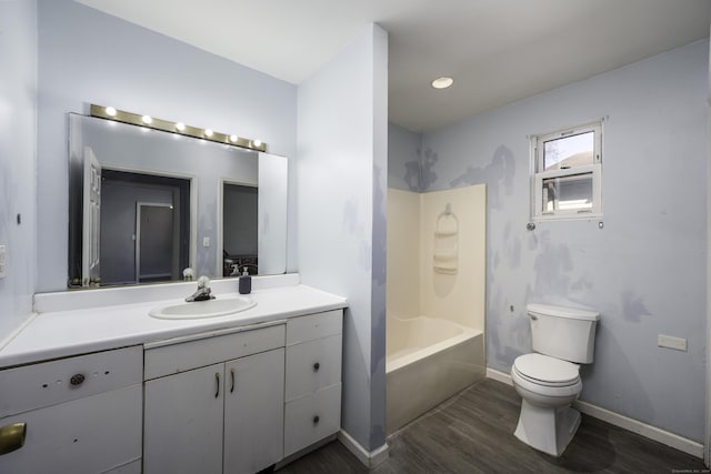 bathroom with toilet, wood finished floors, washtub / shower combination, baseboards, and vanity