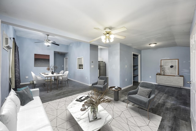 living area with wood finished floors, baseboards, ceiling fan, and vaulted ceiling