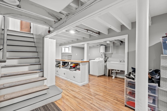 interior space featuring light wood-type flooring, washer / clothes dryer, stairs, and a sink