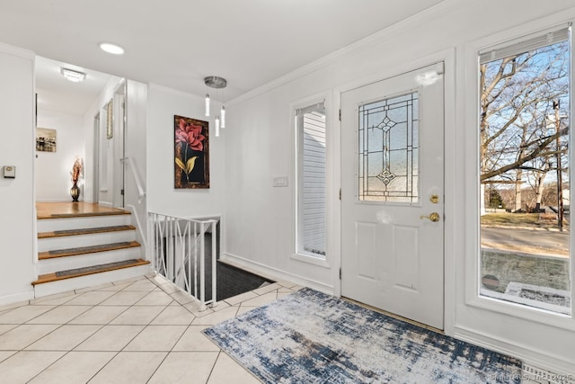 foyer with light tile patterned floors, stairway, baseboards, and ornamental molding