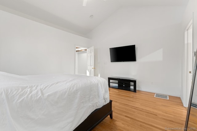 bedroom with visible vents, baseboards, light wood-type flooring, lofted ceiling, and a ceiling fan