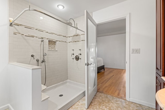 full bathroom with tiled shower and ensuite bathroom