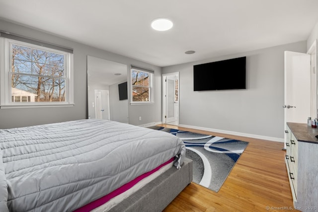 bedroom with light wood-type flooring and baseboards