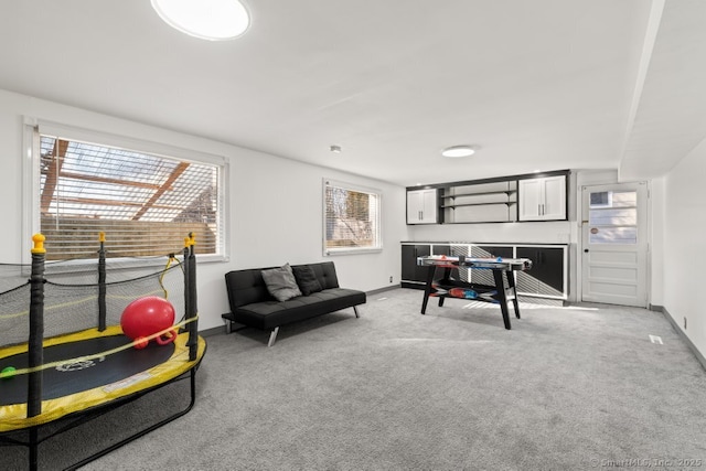 recreation room featuring baseboards and light colored carpet