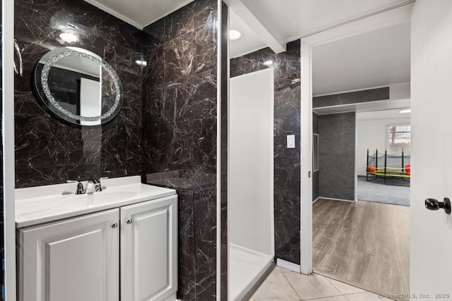 bathroom with tile walls, vanity, and tile patterned flooring