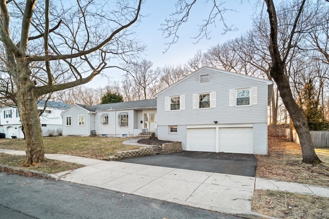 split level home featuring entry steps, a garage, and driveway