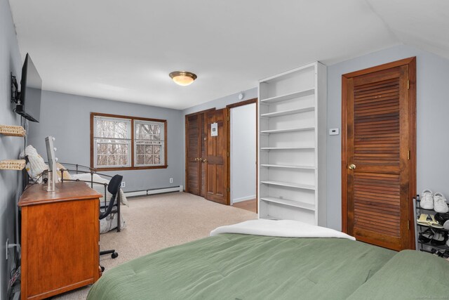 bedroom featuring a baseboard heating unit, lofted ceiling, and carpet floors