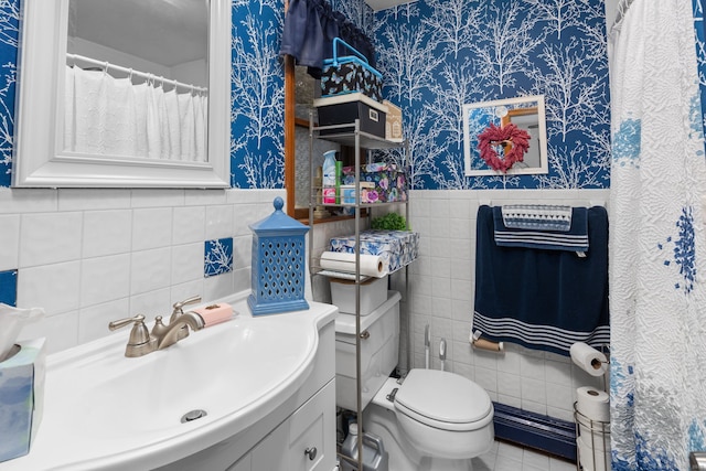 bathroom featuring a wainscoted wall, toilet, and wallpapered walls