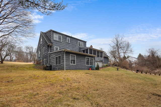 back of house featuring a chimney and a yard