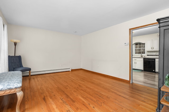 living area featuring light wood-style floors, baseboards, and a baseboard radiator