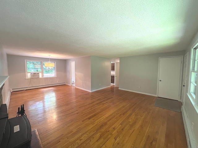 unfurnished living room with a baseboard radiator, light wood-style floors, and a textured ceiling