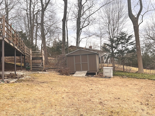 view of yard with a shed, stairs, and an outdoor structure