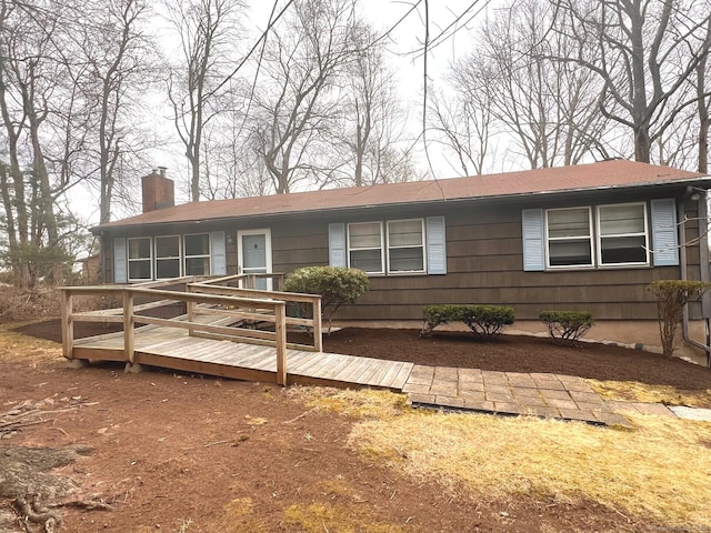 ranch-style home featuring a chimney and a deck