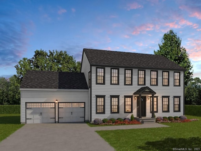 colonial house with a lawn, roof with shingles, concrete driveway, and an attached garage