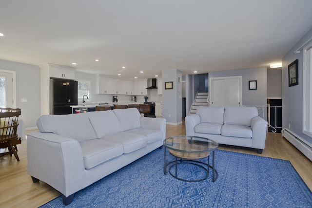 living room featuring baseboards, recessed lighting, light wood-type flooring, and a baseboard radiator