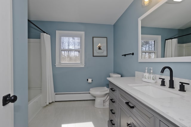 bathroom featuring a baseboard heating unit, toilet, vanity, and a wealth of natural light