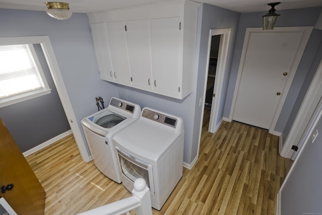 washroom featuring washer and clothes dryer, baseboards, and light wood-style floors