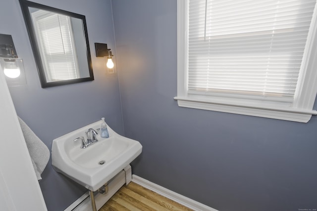 bathroom featuring a sink, baseboards, and wood finished floors