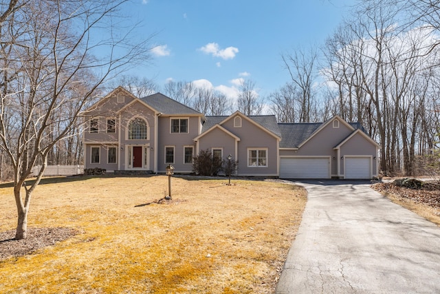 view of front of home with driveway, a shingled roof, and a garage