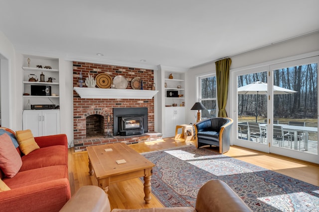 living room featuring built in features, a fireplace, and wood finished floors