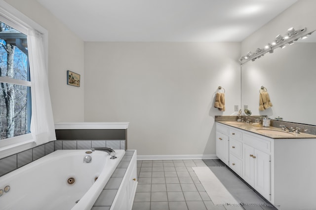 bathroom with double vanity, a whirlpool tub, baseboards, and a sink