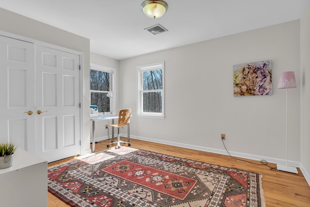 interior space featuring light wood finished floors, visible vents, and baseboards