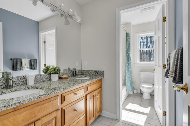 full bathroom featuring a sink, toilet, double vanity, and tile patterned flooring