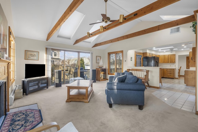 living area featuring visible vents, light carpet, beam ceiling, a skylight, and ceiling fan