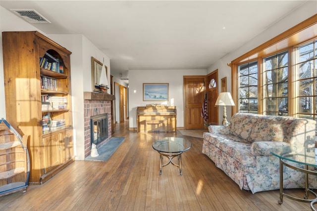 living room featuring hardwood / wood-style floors, a fireplace, and visible vents