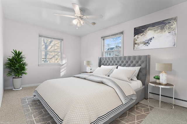 bedroom featuring a baseboard heating unit, baseboards, carpet, and a ceiling fan