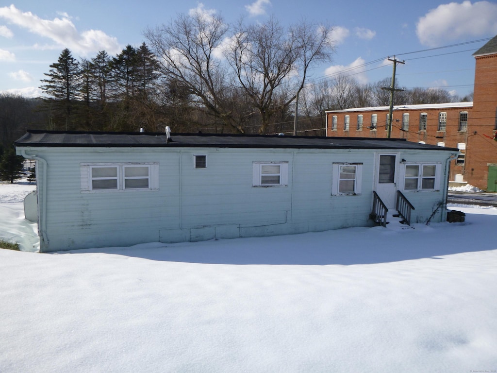 view of snow covered rear of property