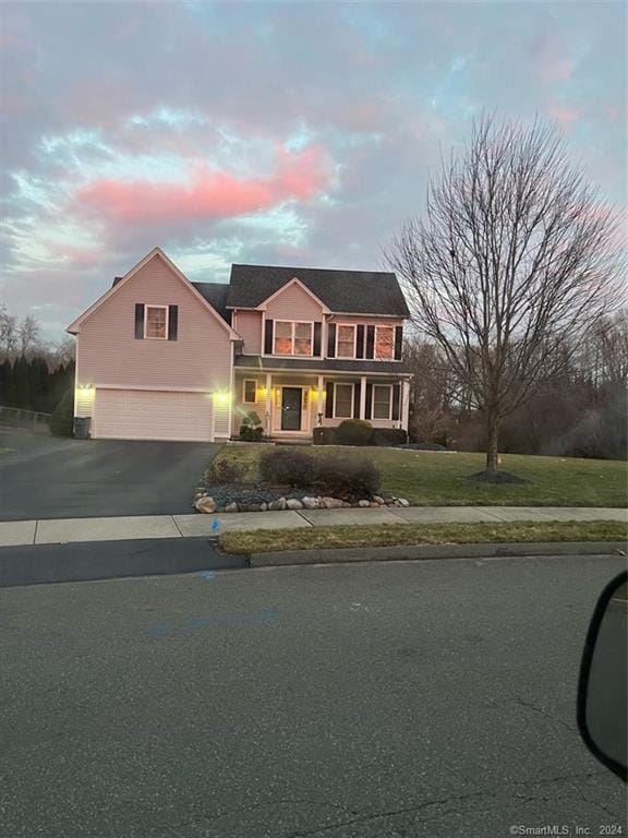 view of front of property with a lawn, driveway, and an attached garage