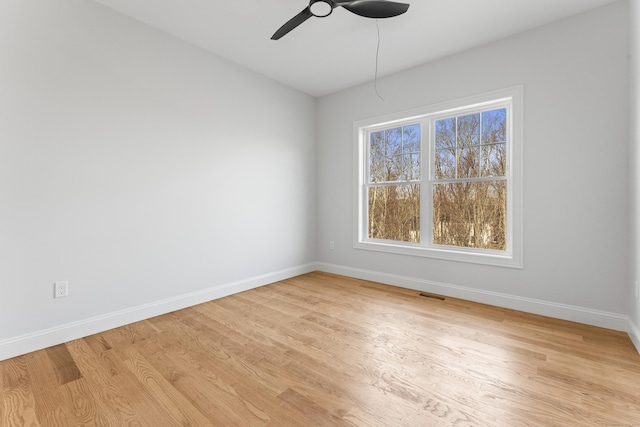 spare room with light wood-type flooring, visible vents, baseboards, and a healthy amount of sunlight