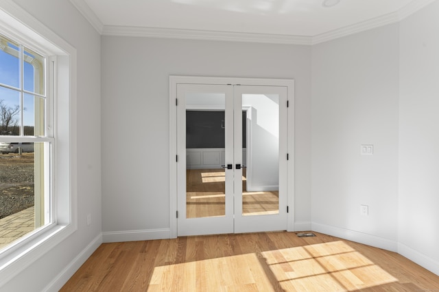 spare room featuring wood finished floors, french doors, baseboards, and ornamental molding