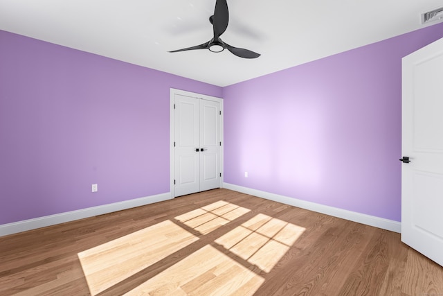 spare room with a ceiling fan, wood finished floors, baseboards, and visible vents