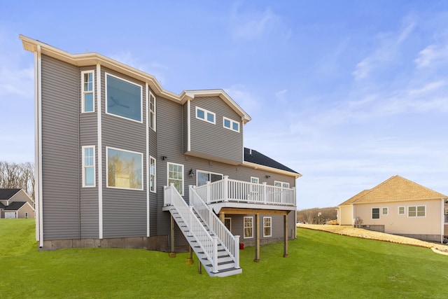 back of house featuring stairway, a lawn, and a deck