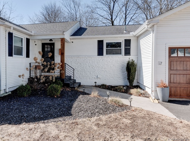 doorway to property with a shingled roof